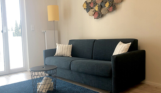 Sofa mit Beistelltisch und Zugang zum Balkon