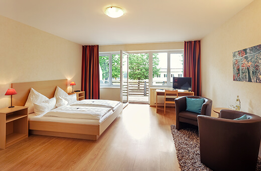 resto web Doppelzimmer mit Doppelbett, Sitz-Ecke mit Sesseln und Schreibtisch